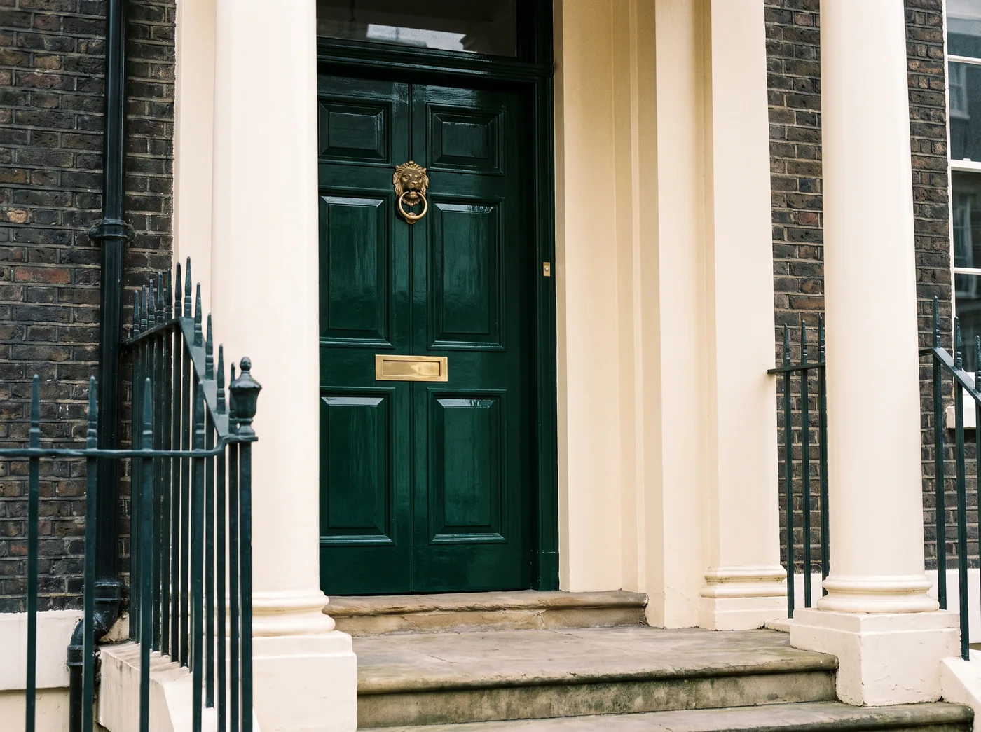 Deep green London townhouse door with brass hardware